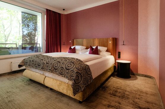 Luxuriöses Hotelzimmer mit großem Bett, Kopfteil und Fenster für Tageslichtfluss